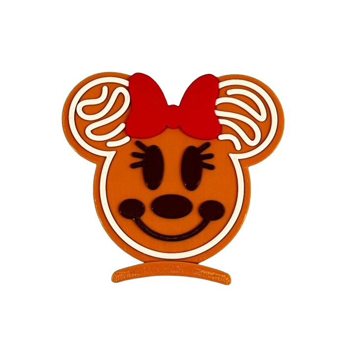 Gingerbread-shaped minnie mouse character with a red bow on a white background