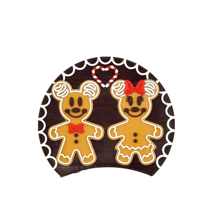 A couple of gingerbread mice standing with a candy cane heart between them. 