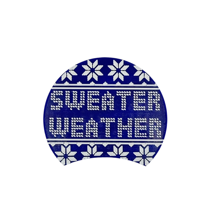 Sweater Weather swappable plate has snowflakes and the expression "sweater weather" in the center. The words looked stitched as in a quilt or ugly christmas sweater. 