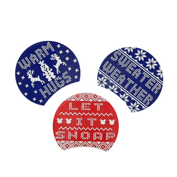 Ugly Sweater Swappable plates include. sayings such as "warm hugs", "sweater weather", and "let it snoap". 